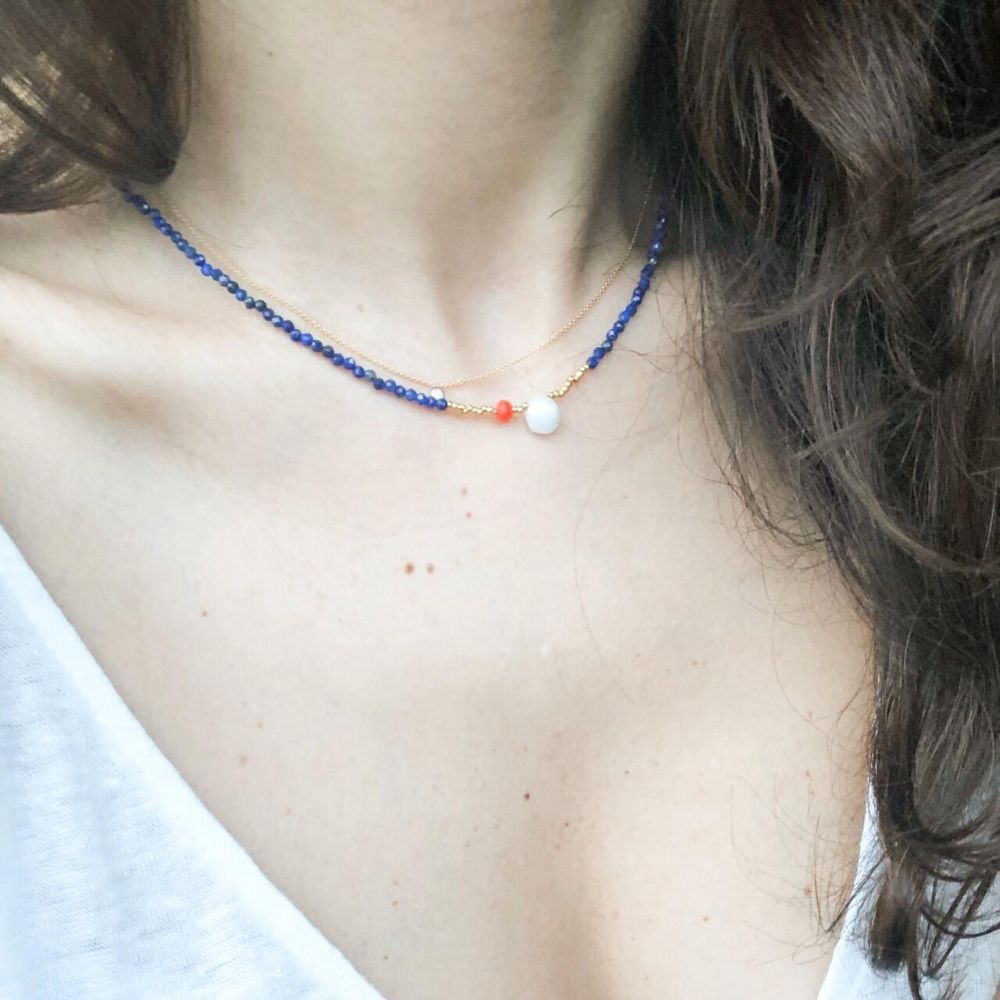 beyaz bluzlu kadının üzerinde lapis lazuli taşlı lacivert kolye