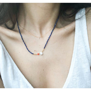 beyaz bluzlu kadının üzerinde lapis lazuli taşlı lacivert kolye