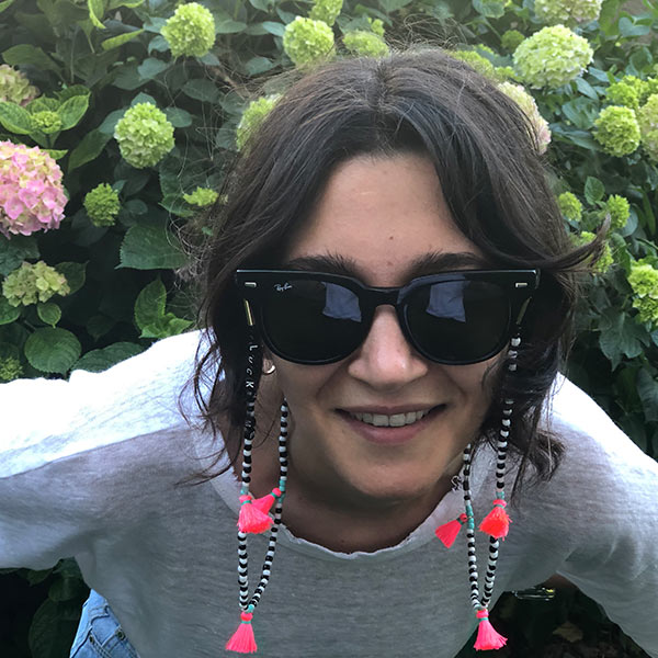 Beyaz tişörtlü kadının üzerinde, Lucky me yazan, siyah beyaz doğal boncuklu, kırmızı ipli, uzun gözlük ipi.