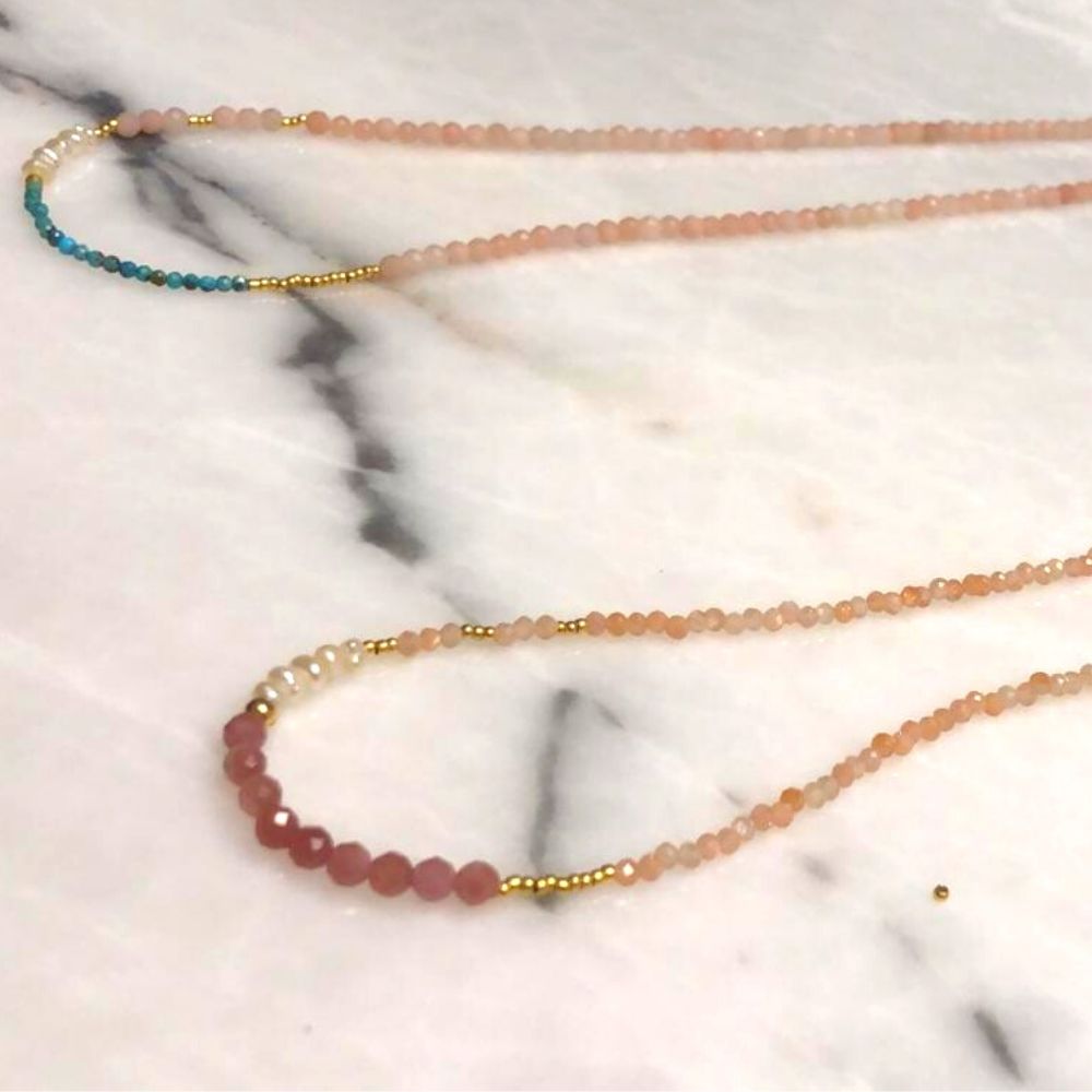  Doğal inciler ve turmalin, güneş taşı doğal taşlarından oluşan pembe tonlarındaki kolye ve turkuaz taşından yapılmış kolye