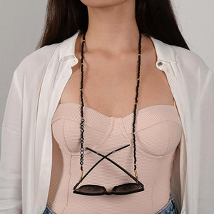 Pembe bluzlu kadının üzerinde siyah boncuklardan oluşan, silikon tutacaklı üzerinde "Heart of Gold" yazan gözlük zinciri