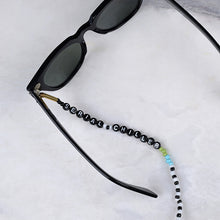 Görseli Galeri görüntüleyiciye yükleyin, Beyaz mermer üzerinde renkli boncuklu, silikon tutacaklık üzerinde &quot;Serial Chiller&quot; yazan gözlük zinciri